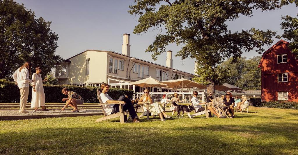 斯德哥尔摩哈根别墅酒店的一群人坐在一座建筑前面的草上