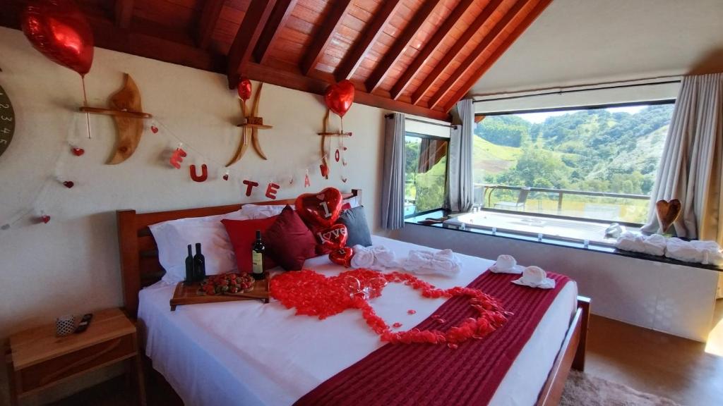 贡萨尔维斯Chales Sabor Dos Ventos的一间卧室,床上有红色的鲜花