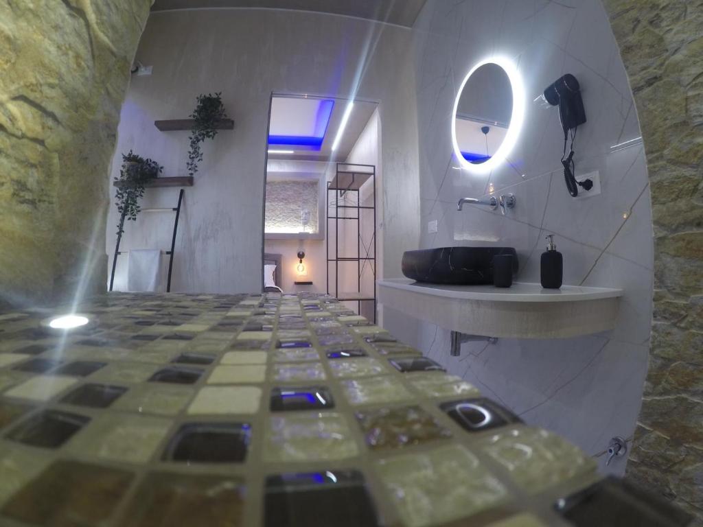 锡拉库扎LE CAMERE Luxury Rooms SIRACUSA的浴室铺有瓷砖地板,配有盥洗池。