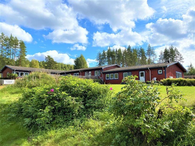 哈格福什Långrösta 48-49, Appartementen in Hagfors的草场上一座大型红色建筑