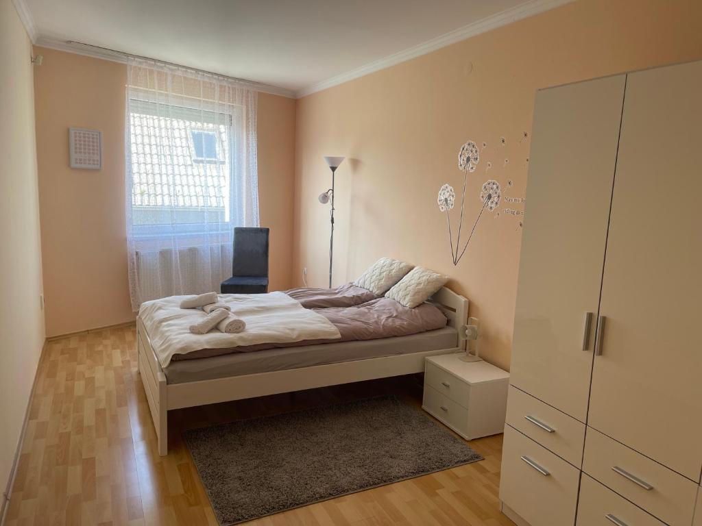 塞格德Noemi Appartman Szeged的一间卧室配有一张床、一个梳妆台和一扇窗户。