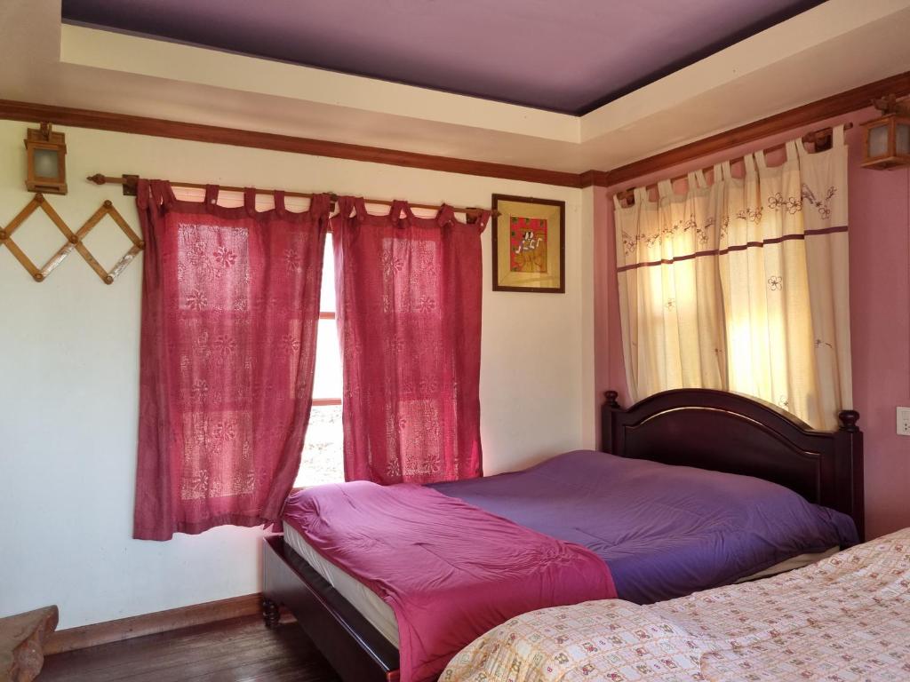 席昌岛Hello Sichang Bungalow的一间卧室配有床和红色窗帘的窗户