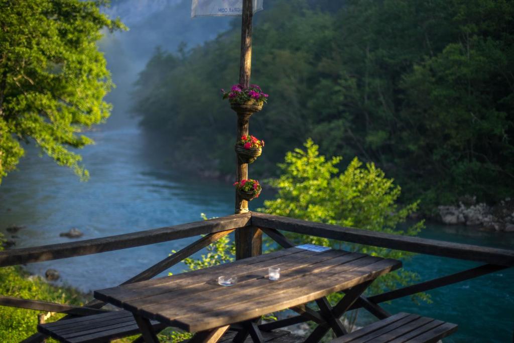 Šćepan-PoljeGRAB ethno village and camp的河边的木桌,花朵