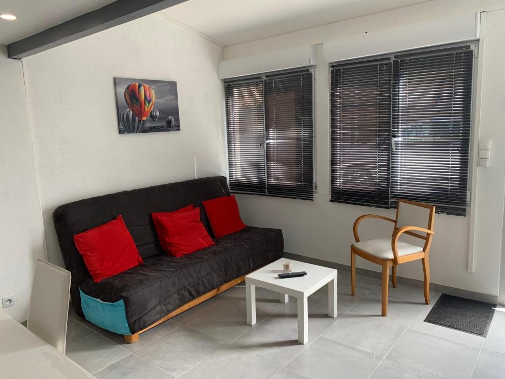 格吕桑L appart d Ange 2 idealement situe 47m2 entre le port et le village的客厅配有黑色沙发和红色枕头