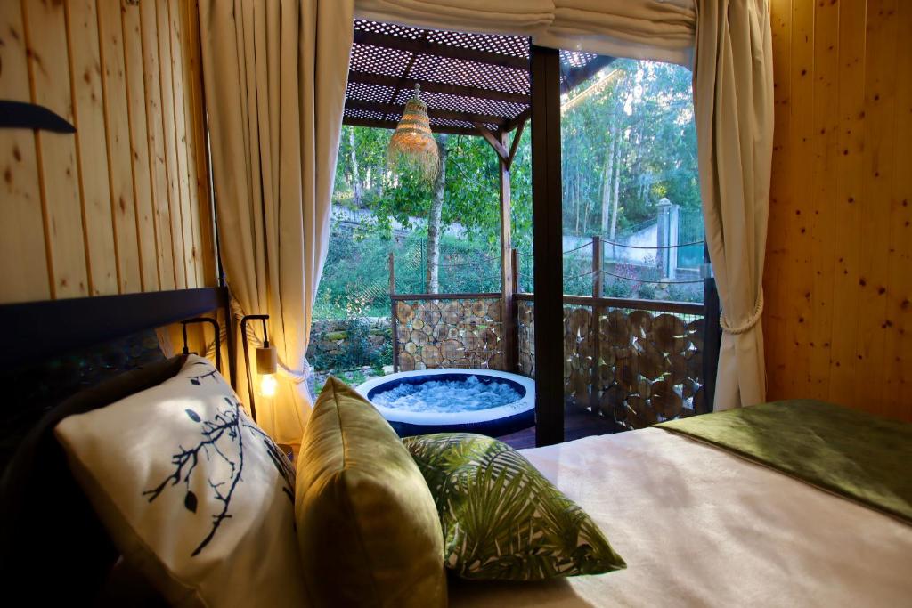 SandimBruval Eco Retreat的一间卧室设有一张床和一个带浴缸的窗户。