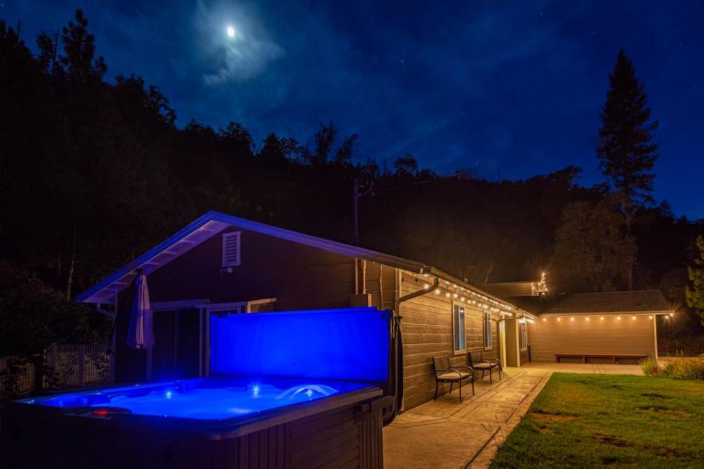 科斯戈尔德Alpine 4 Bedroom Retreat with Hot tub and Pool table的夜间房子后院的热水浴池