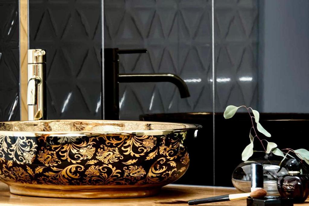 卢布明Residence Black Eagle Lubmin Strand的浴室内一个柜台上的黑金碗