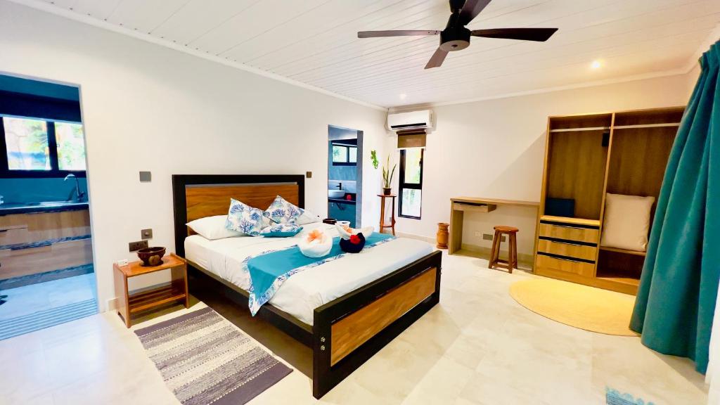 贝圣安那乐港宾馆的一间卧室配有一张床和吊扇