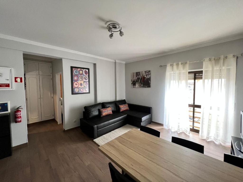 阿莫拉巴老公寓的客厅配有黑色沙发和桌子