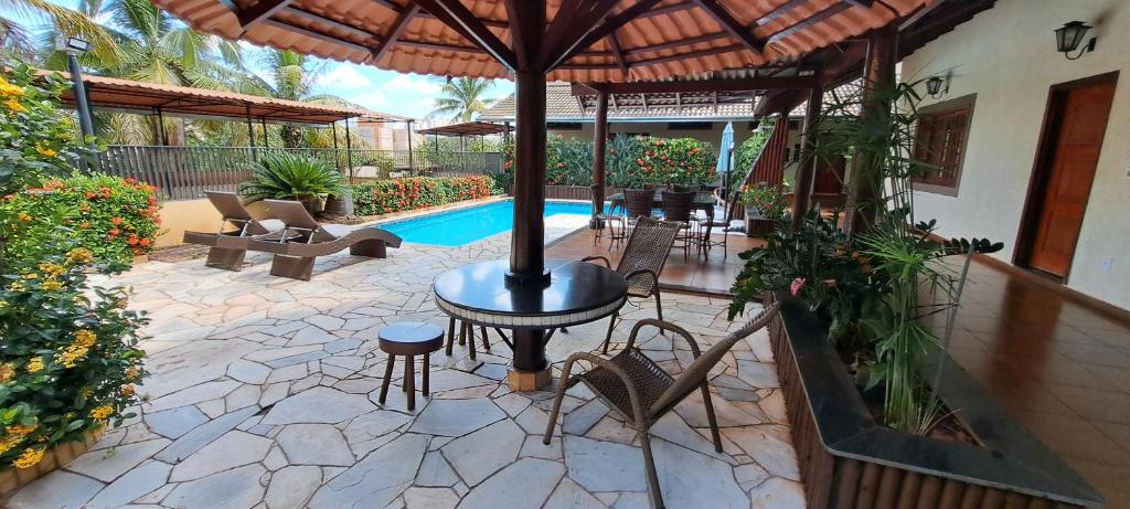 里贝朗普雷托Pousada Villa D' Garden的一个带桌椅的庭院和一个游泳池