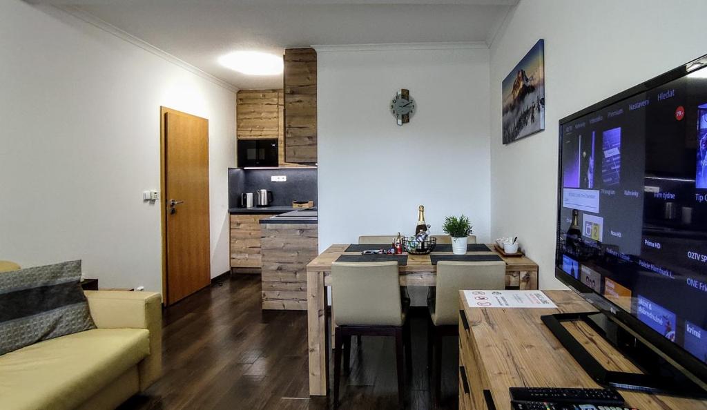 哈拉霍夫Horský rodinný apartmán 2KK s velkou terasou, s wellness, snídaní na pokoj a s vlastním parkováním v garáži - by Relax Harrachov的客厅设有餐桌和厨房