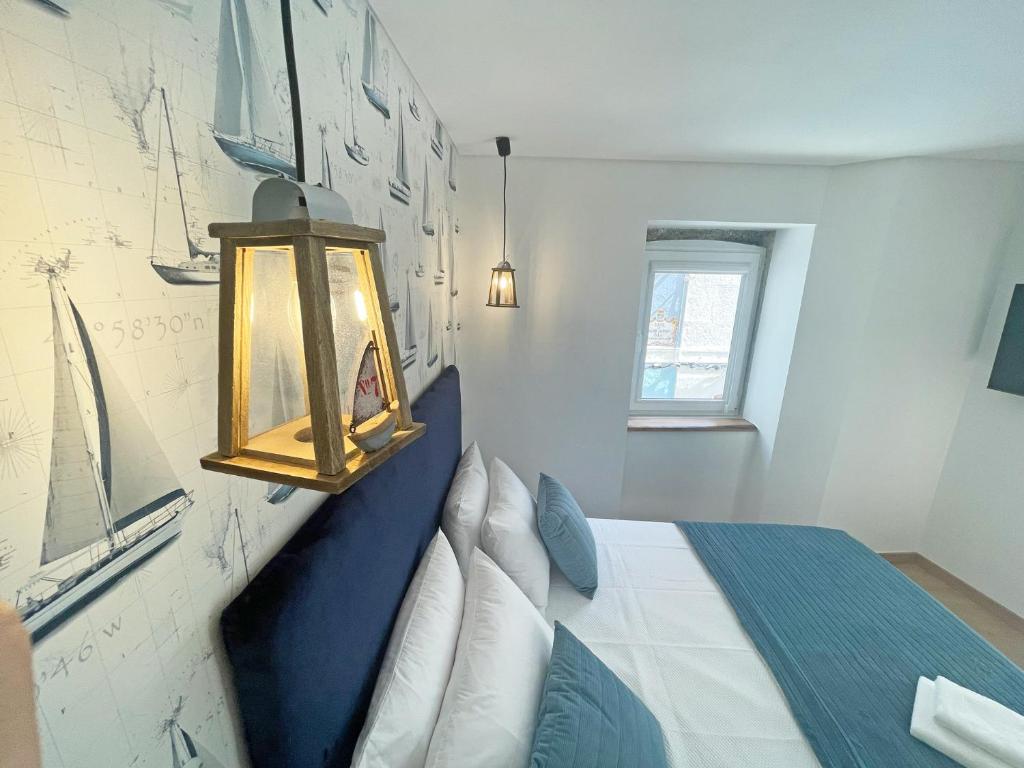 塞图巴尔Baia do Mundo的卧室配有蓝色和白色的床和灯。