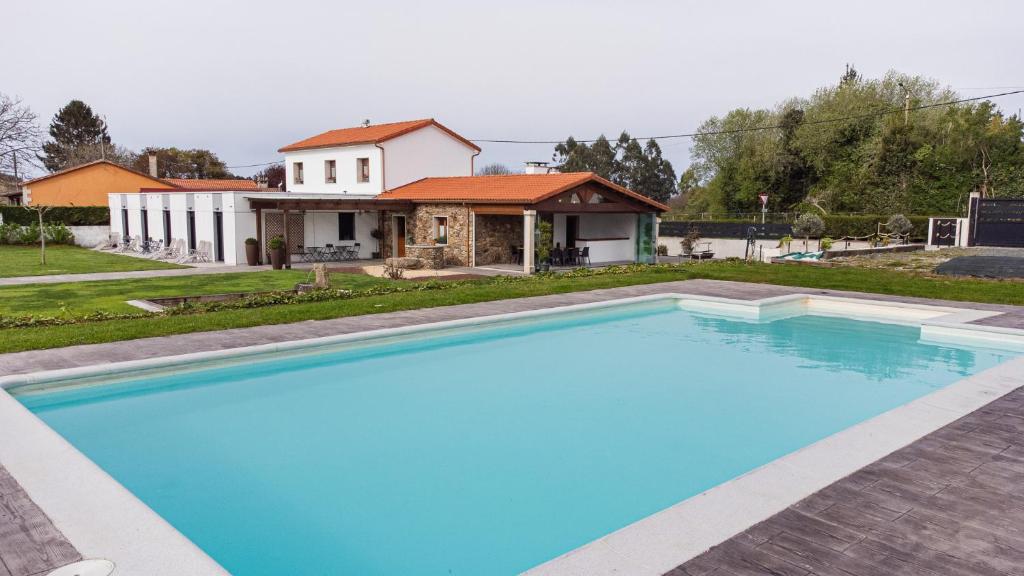 BoimortoCasa O Real的一座大蓝色游泳池,位于房子前