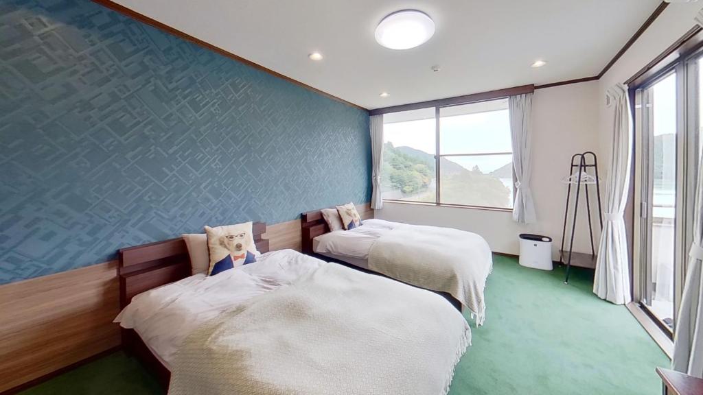 云仙市H,U,B Unzen - Vacation STAY 01672v的蓝色墙壁客房的两张床