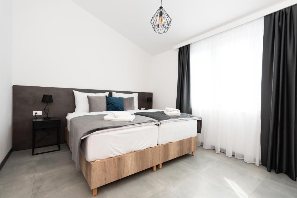 卡什泰拉Kapov's Rooms的一间卧室配有一张带白色床单和蓝色枕头的大床。