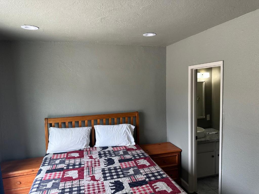 奥克赫斯特山间步道出租度假山林小屋的一间卧室，床上铺着被子