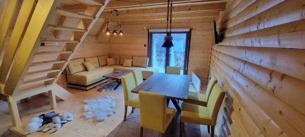 Crni VrhApartmani Prica的小屋内带桌椅的用餐室