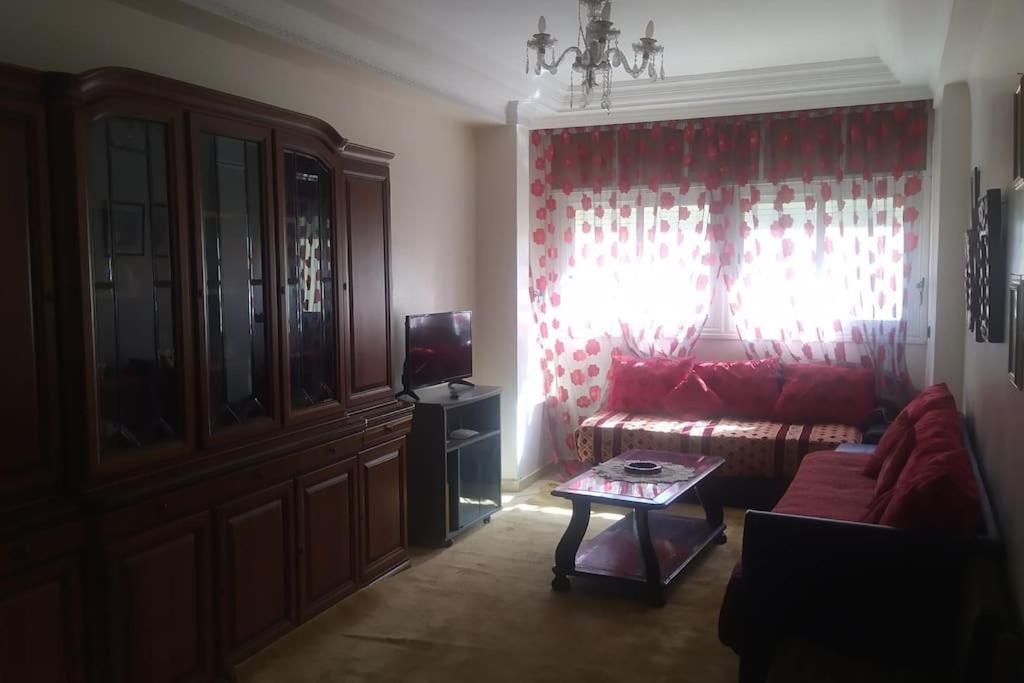 卡萨布兰卡Appartement à casablanca的客厅配有红色的沙发和桌子