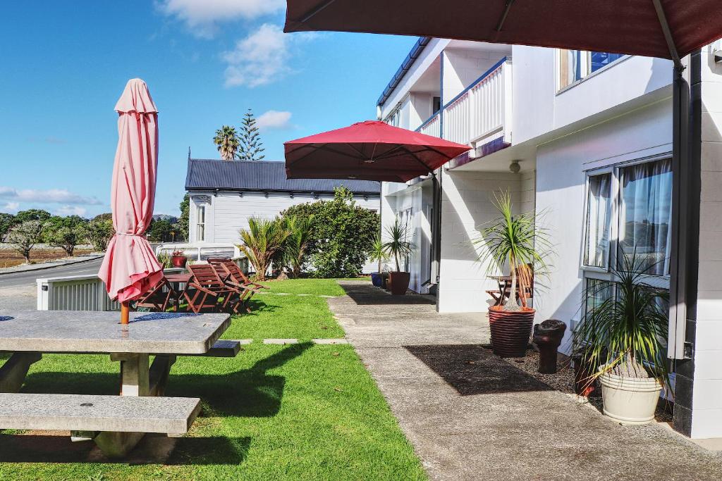 芒奥努伊阿尔路易丝公寓的庭院配有遮阳伞和桌椅。