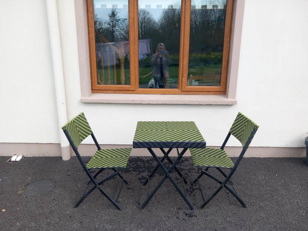 恩尼斯Larchlodge的窗前的两把椅子和一张桌子