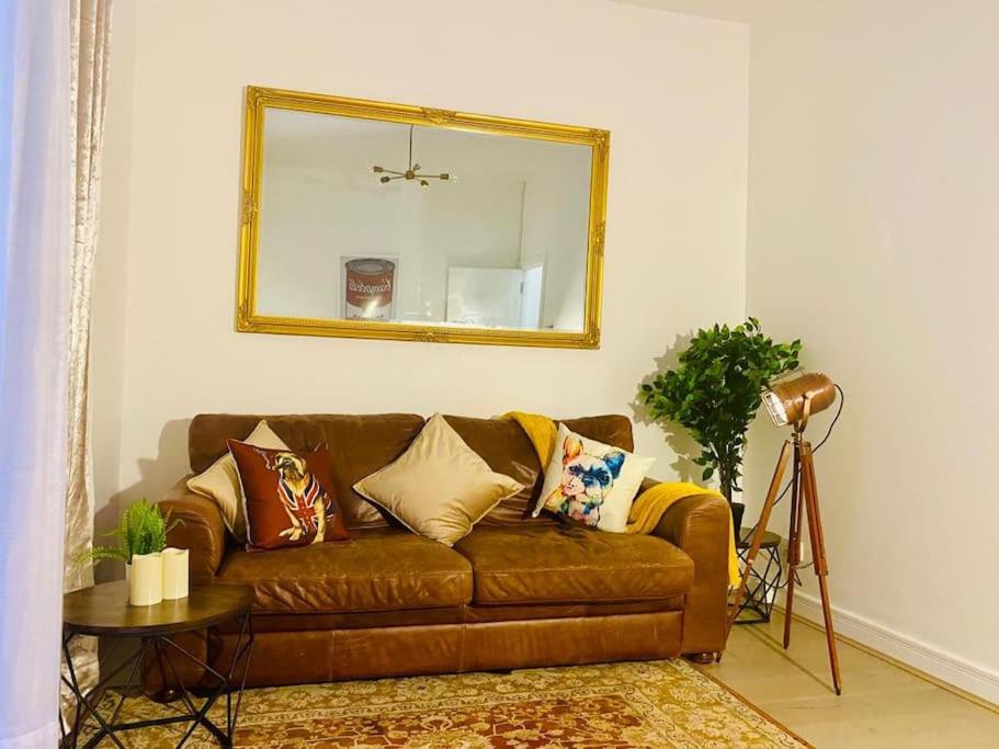 伦敦Sanctuary Spaces at The Shard with private parking的客厅里一张带镜子的棕色沙发