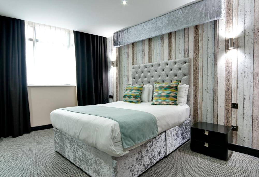 利物浦普瑞沃克斯公寓式酒店的一间卧室配有一张大床和大床头板
