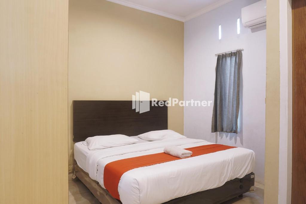 占碑市Tassa Homestay Syariah Mitra RedDoorz的一间卧室,卧室内配有一张大床