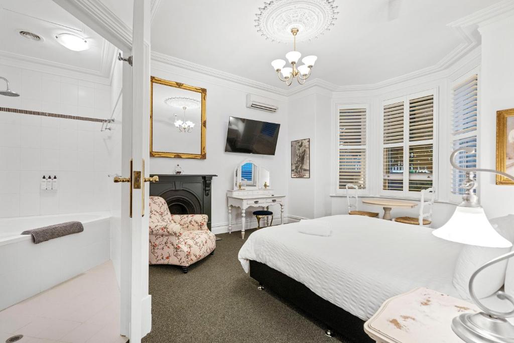 弗里曼特Accommodation in Fremantle的一间白色卧室,配有一张床和一个壁炉