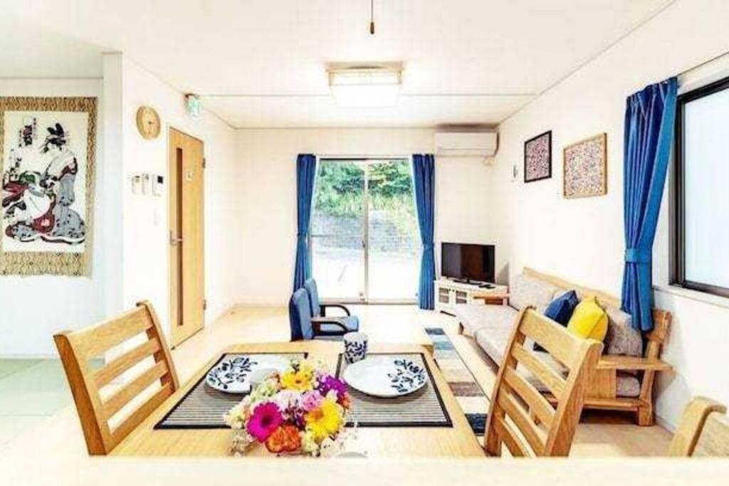 恩纳我が家inOKINAWA 私の家in沖縄的客厅设有餐桌和椅子