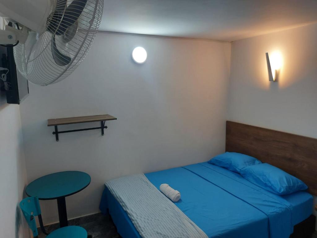 伊瓦格HOTEL DEPARTAMENTAL的一间设有蓝色床和凳子的小卧室