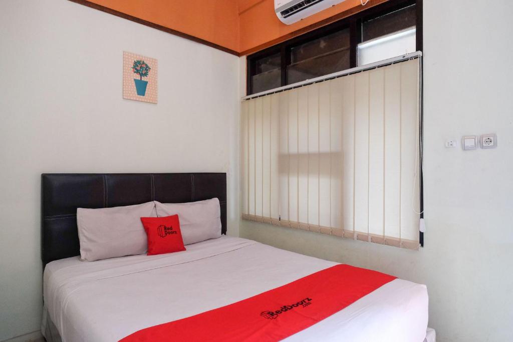 日惹RedDoorz near Lotte Mart Maguwoharjo Yogyakarta的一间卧室配有一张红色枕头的床