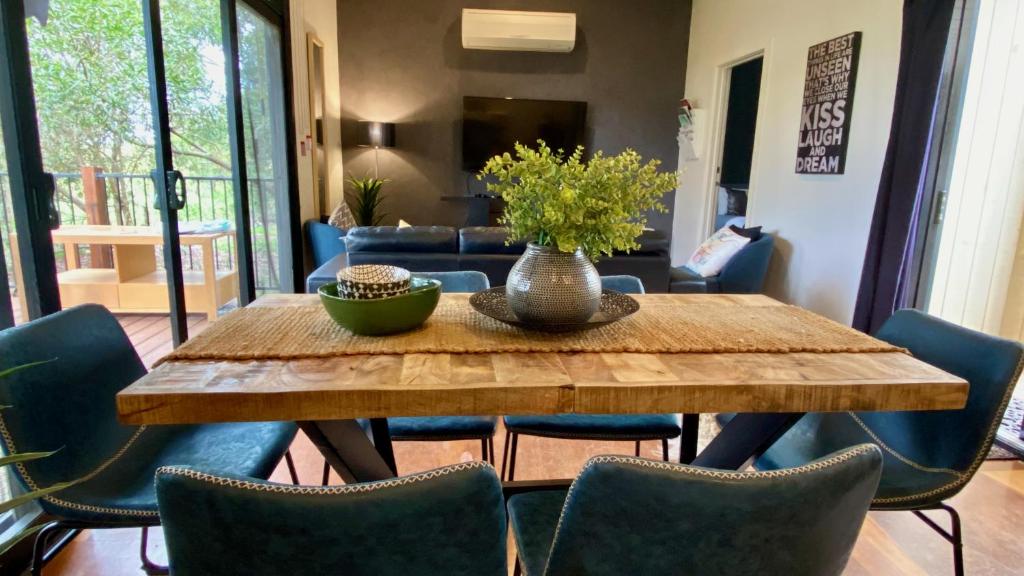 卡尔斯Phillip Island Nature Resort Villas的餐桌、椅子和花瓶