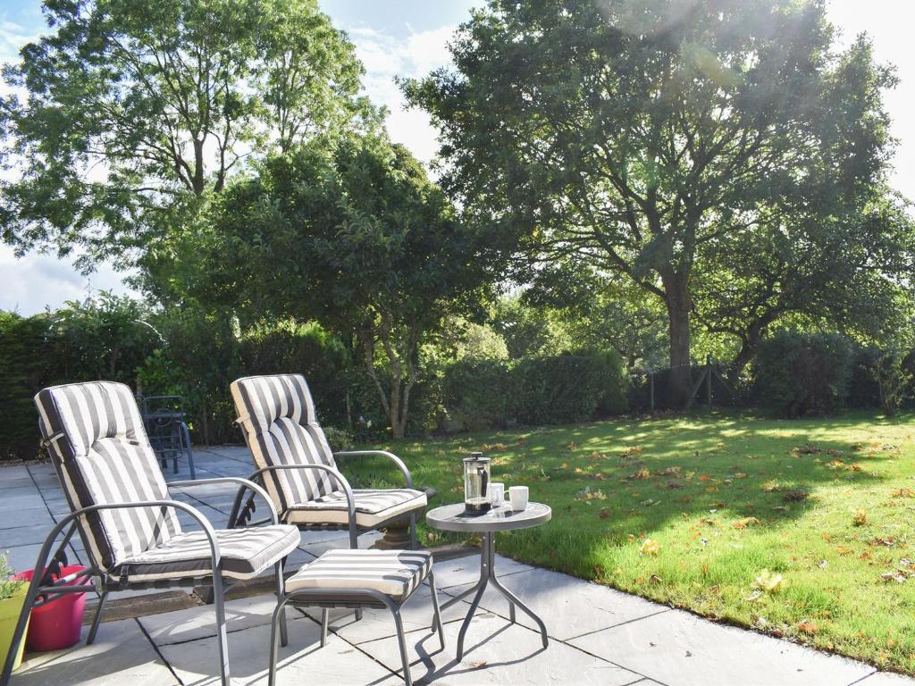 WingerworthStone Cottage的庭院里设有两把椅子和一张桌子