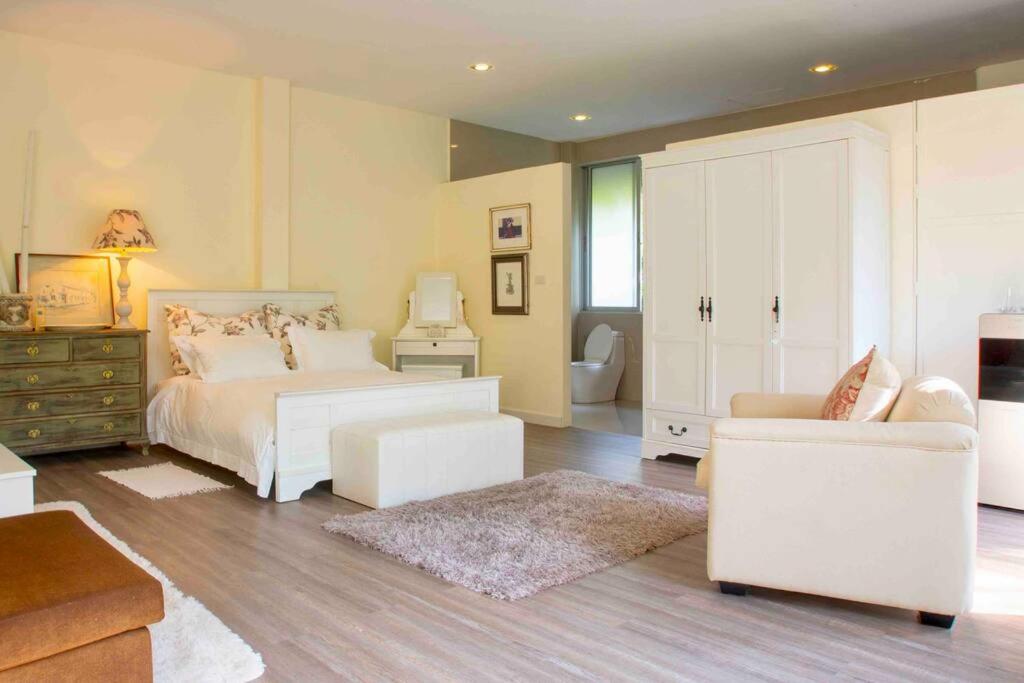 美翰VillaMilla deluxe en-suite room的卧室配有白色的床、沙发和椅子