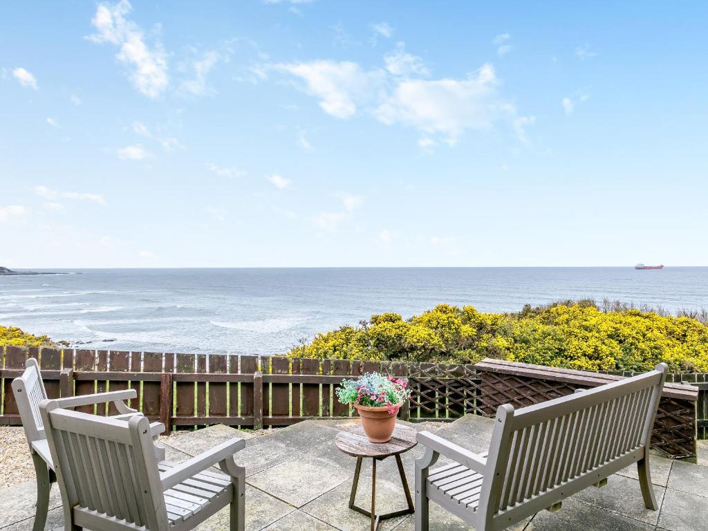 班夫海景酒店的一个带两把椅子和一张桌子的庭院和大海