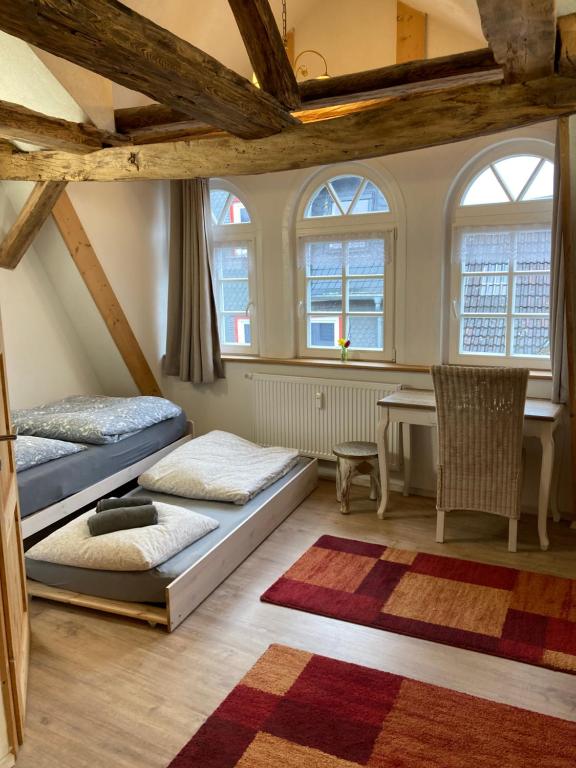 巴特赫尔斯费尔德Gästehaus Keins wie meins的配有桌子和窗户的客房内的两张床