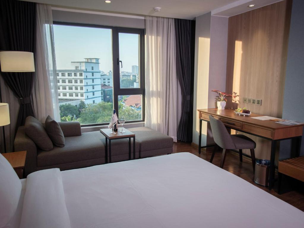 仰光Prince Hotel的配有一张床、一张书桌和一扇窗户的酒店客房