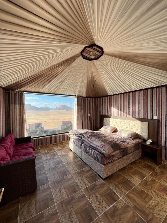 瓦迪拉姆Wadi Rum Mars Camp的一间卧室设有一张床和一个大窗户