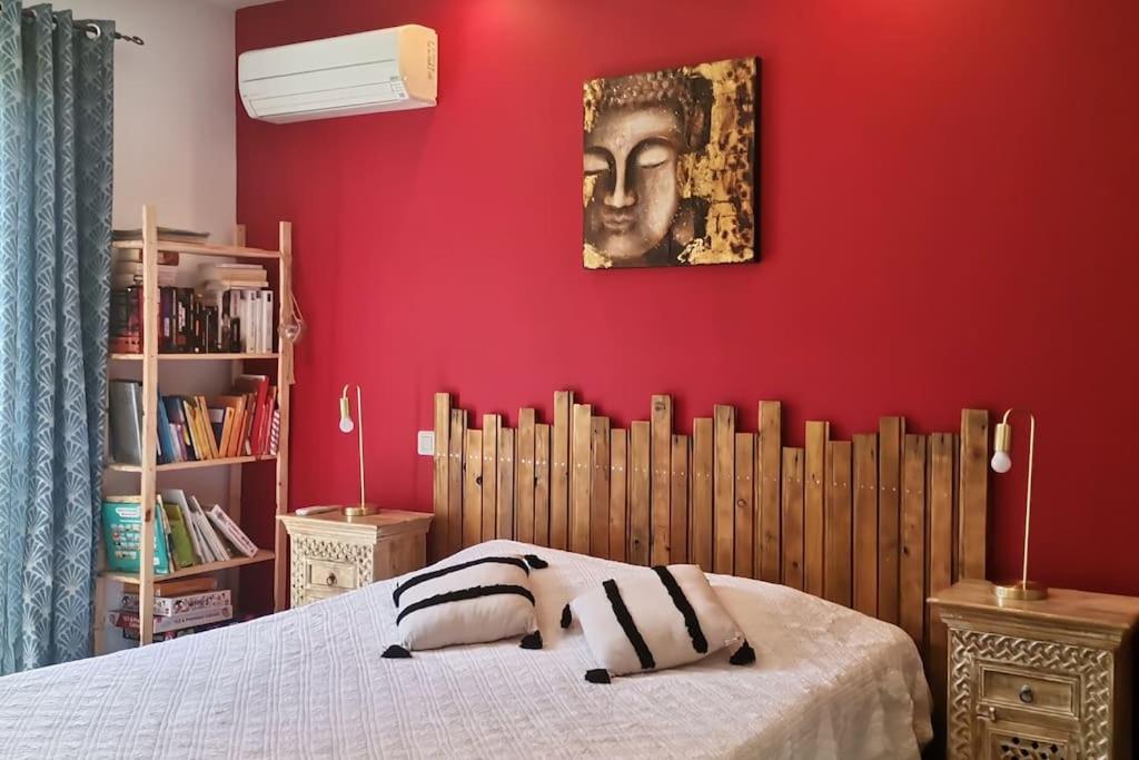费里切托Maison avec jacuzzi au cœur des montagnes的一间卧室设有红色的墙壁和一张带两个枕头的床