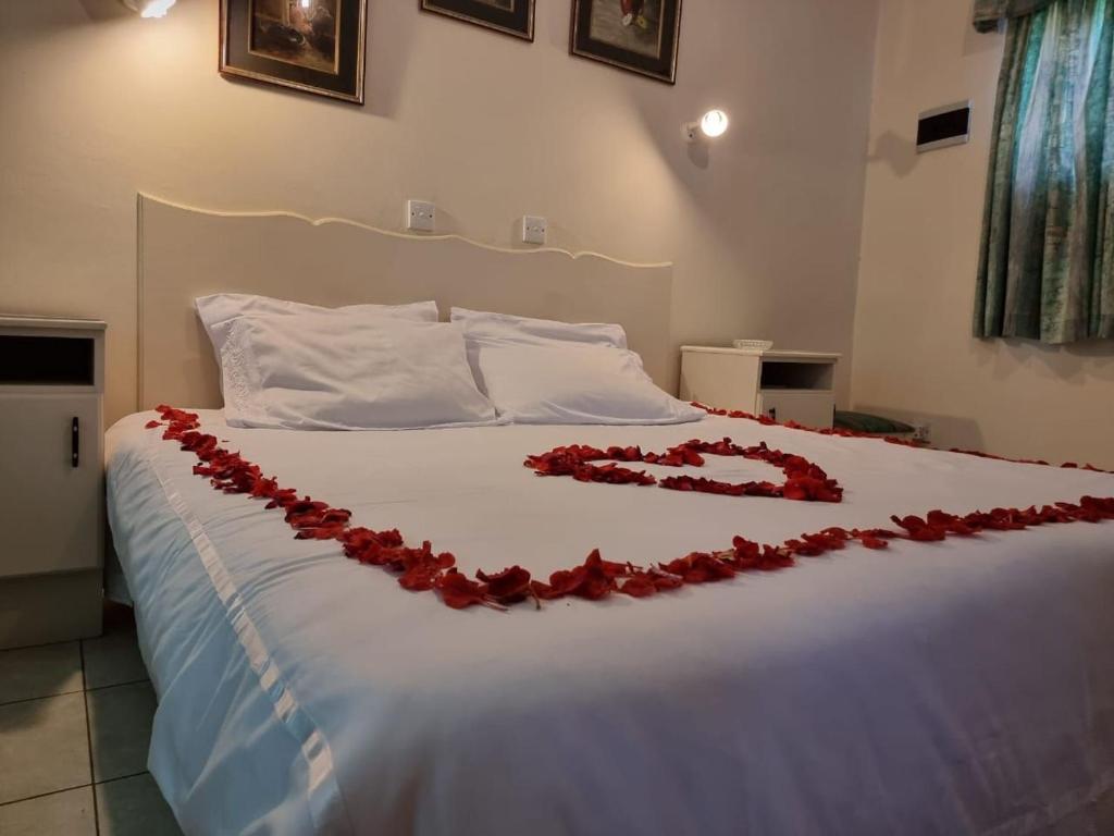 布拉瓦约Neat standard room in guesthouse - 2088的一张床上有红玫瑰装饰