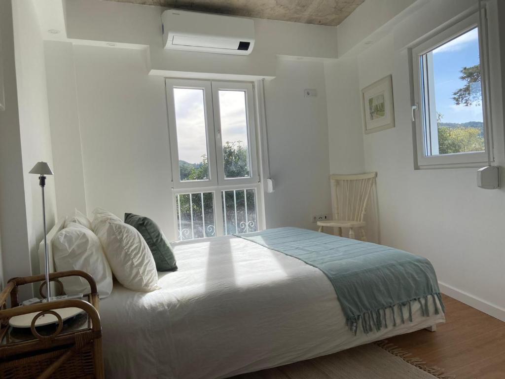 塞图巴尔Lovers House的一间卧室设有一张大床和两个窗户