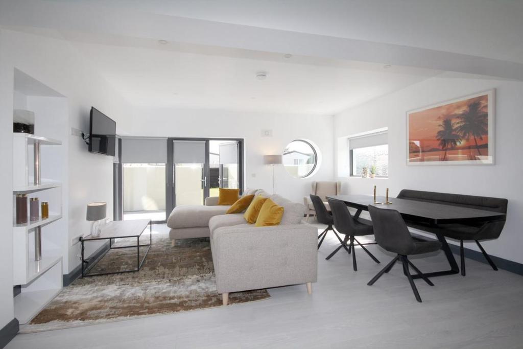 罗斯莱尔Burrow Park Holiday Apartments的白色的客厅配有桌子和沙发