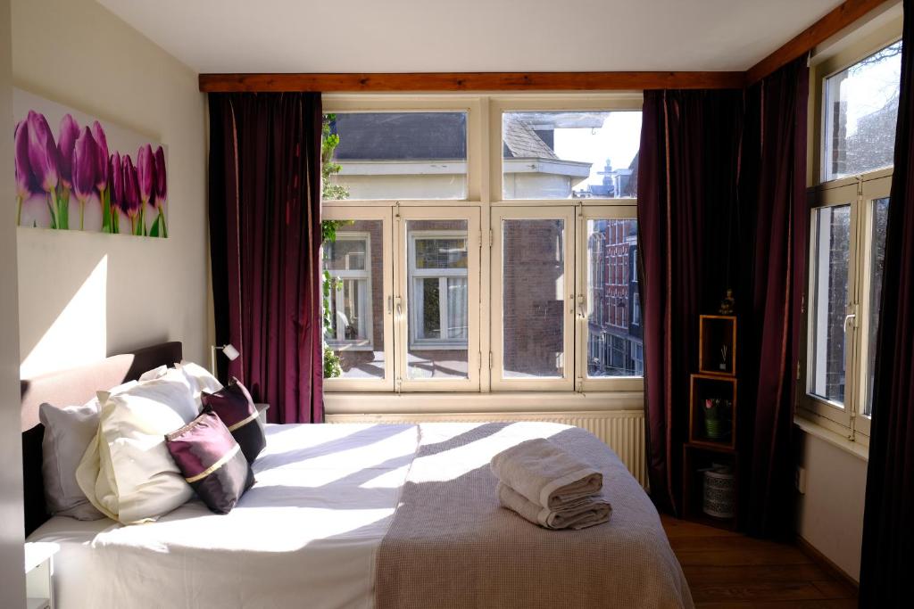 阿姆斯特丹Eelhouse private studio的卧室配有白色的床和窗户。