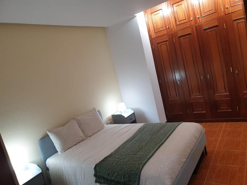 维拉·雷阿尔Cantinho dos Montes的一间卧室配有一张床和两个木制橱柜。