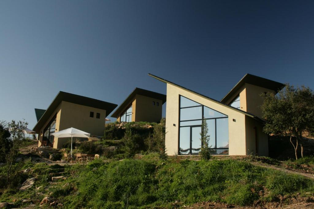 萨兰达Botë Farms Agriturismo的山丘上的房子,设有大窗户