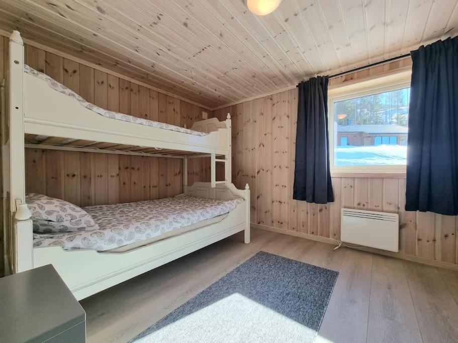弗罗达尔Holiday cabin in beautiful surroundings的一间卧室设有两张双层床和一扇窗户。