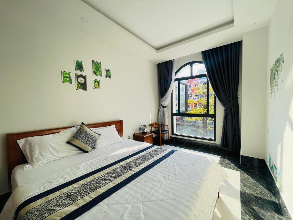 富国Coffee Pacific Grand World Phú Quốc的一间卧室设有一张大床和一个窗户。