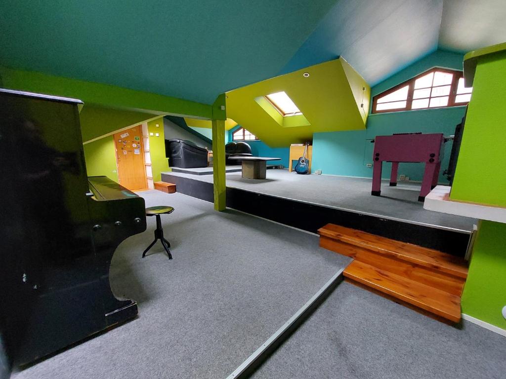 维尔纽斯25 Hours Hostel的客厅设有绿色和黄色的墙壁和电视。