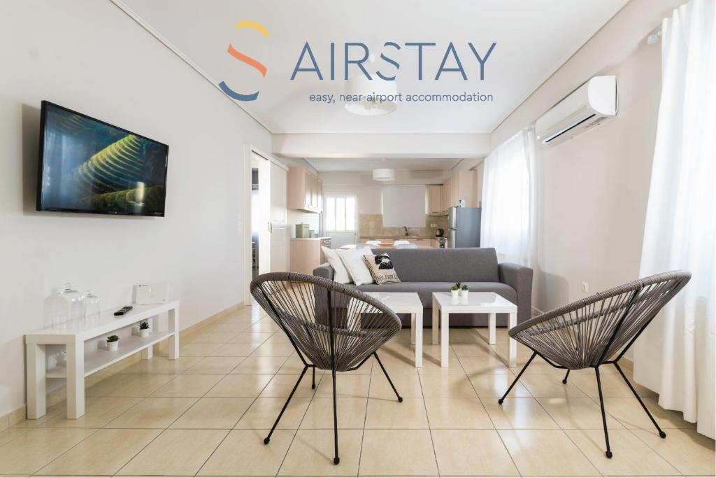 斯巴达Elise Apartment Airport by Airstay的客厅配有两把椅子和一张沙发