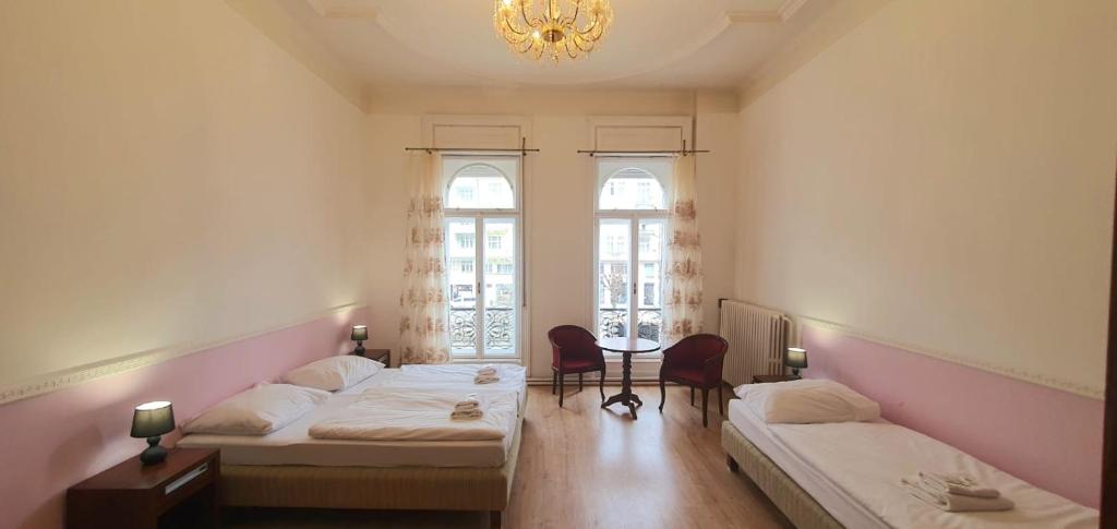 卡罗维发利帕拉茨基酒店的客房设有两张床和一张带吊灯的桌子。